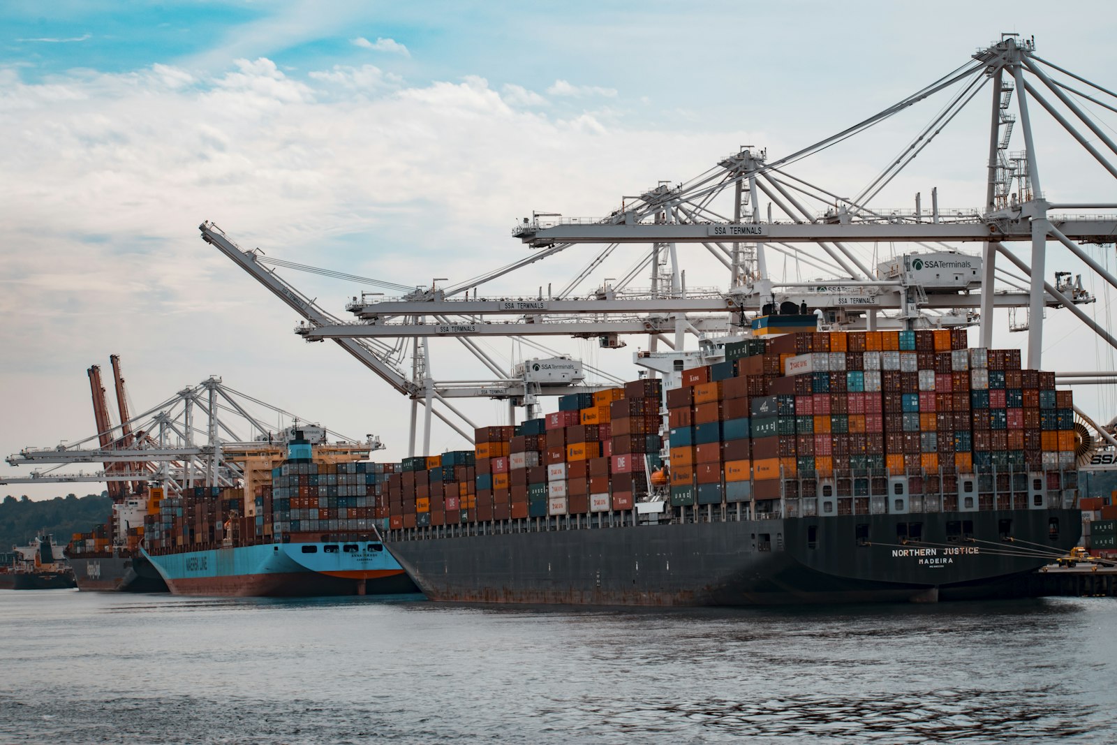 Container ship being unloaded by cranes at a freight port